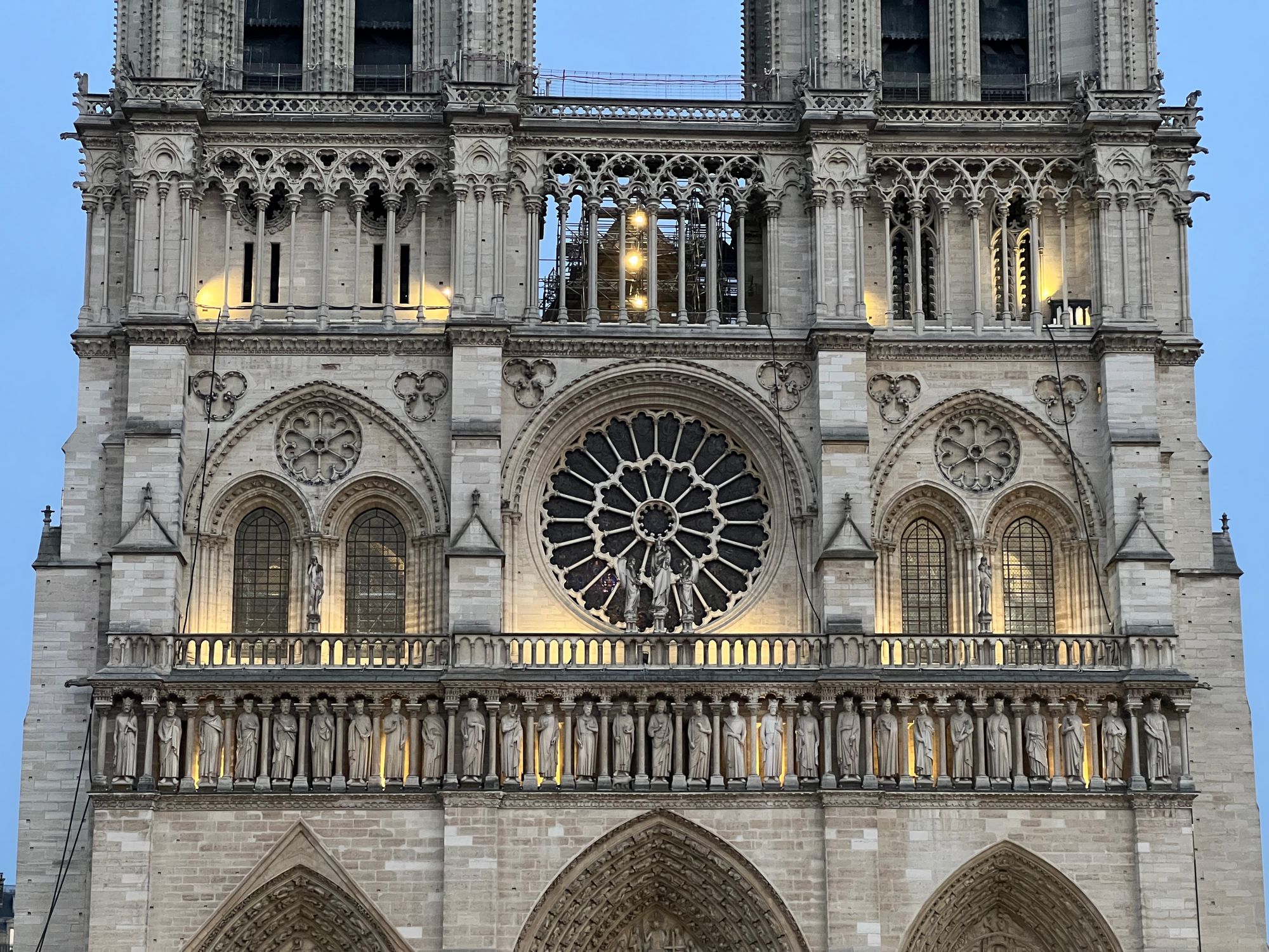 One of the nave walls of Notre Dame, with a circular window at the centre. Scaffolding is visible behind pillars.