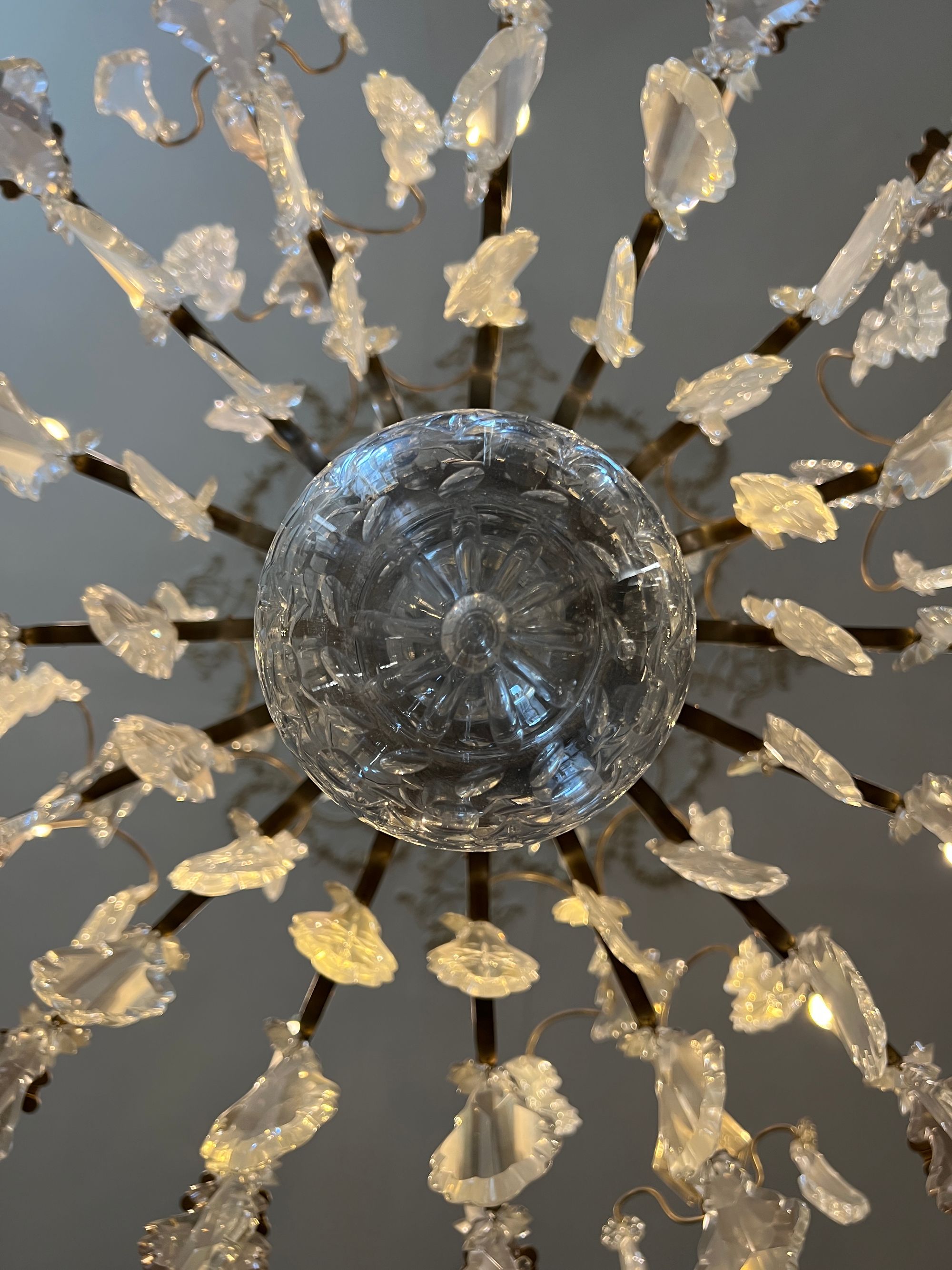 From below, a large glass chandelier with dangling ‘shards’ and a large glass sphere in the centre.