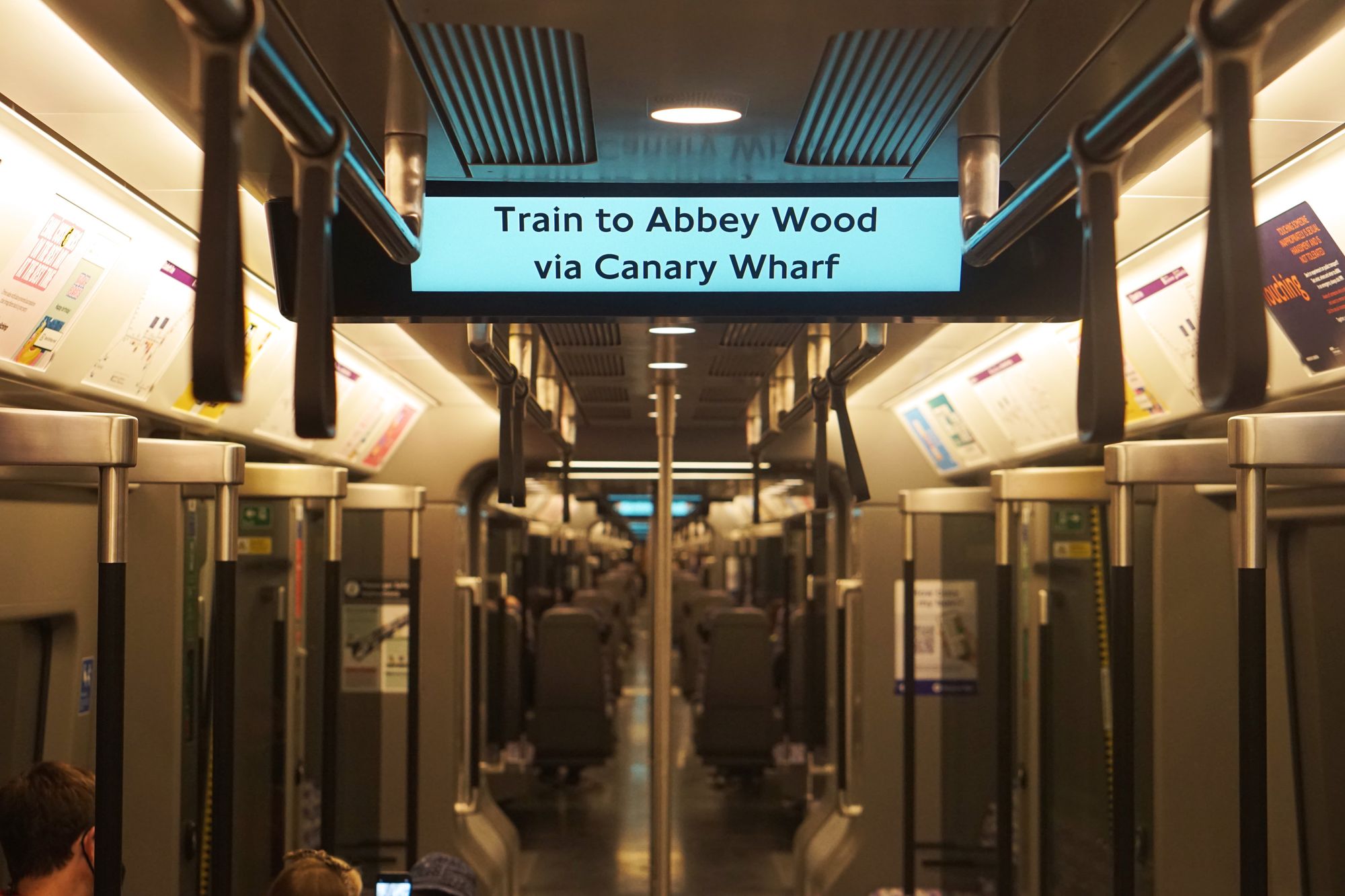 View through an Elizabeth line train. Screen says "Train to Abbey Wood via Canary Wharf."