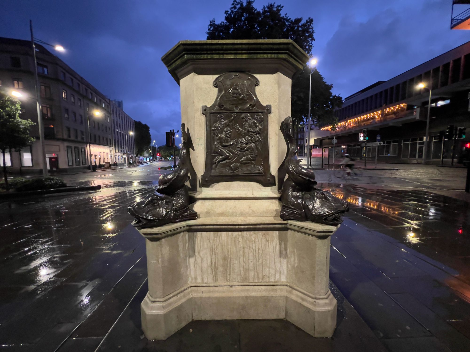An empty statue plinth on a rainy square with ornate carvings. The statue (of slaver Edward Colston) is missing.