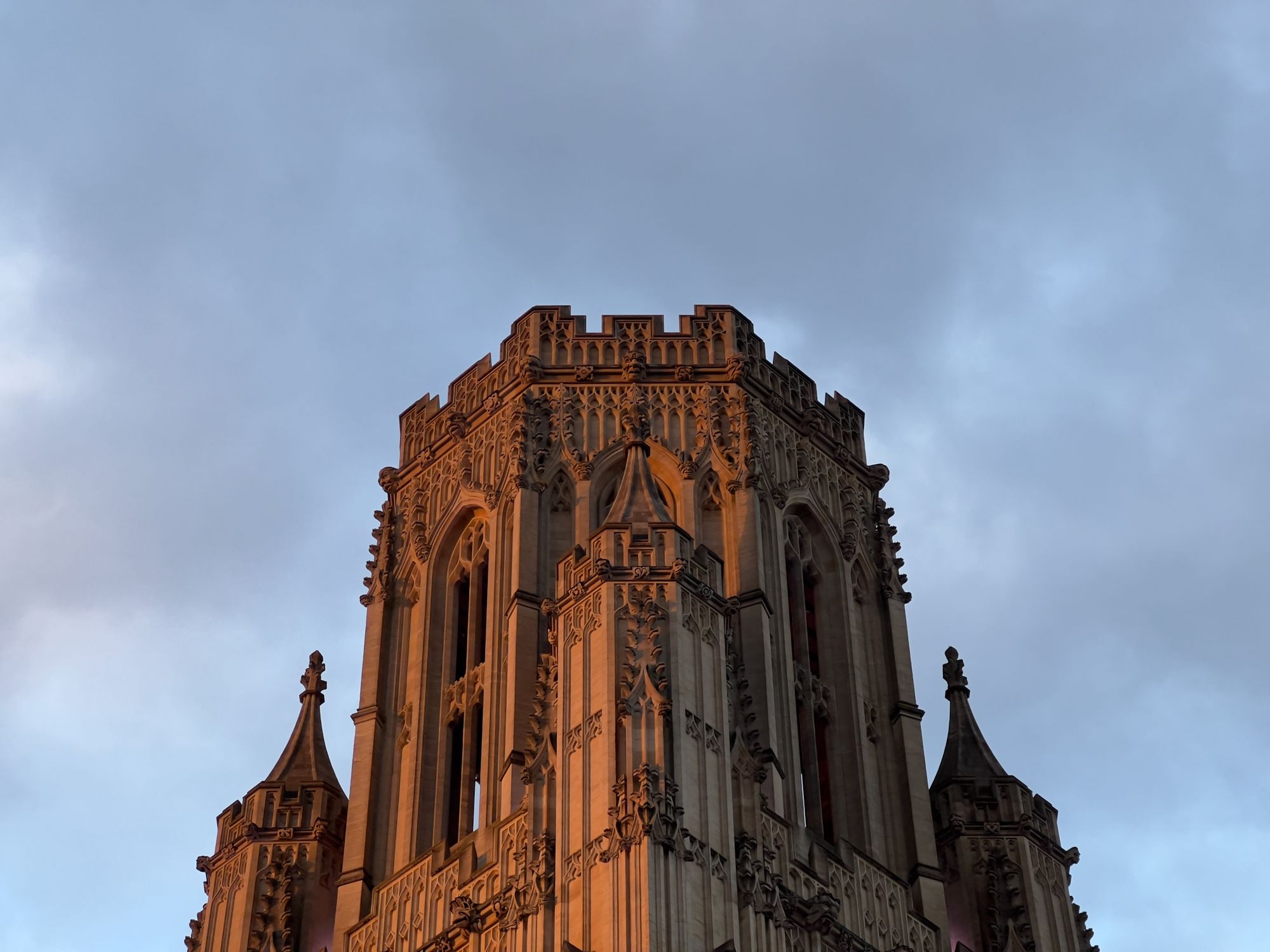 The top of a Gothic bell tower at sunset.