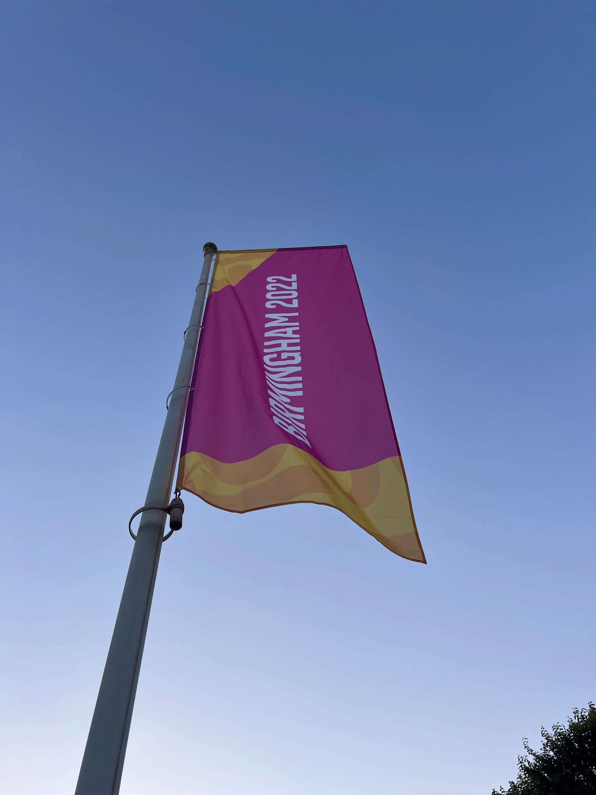 A large vertical banner against a blue sky reads "BIRMINGHAM 2022."