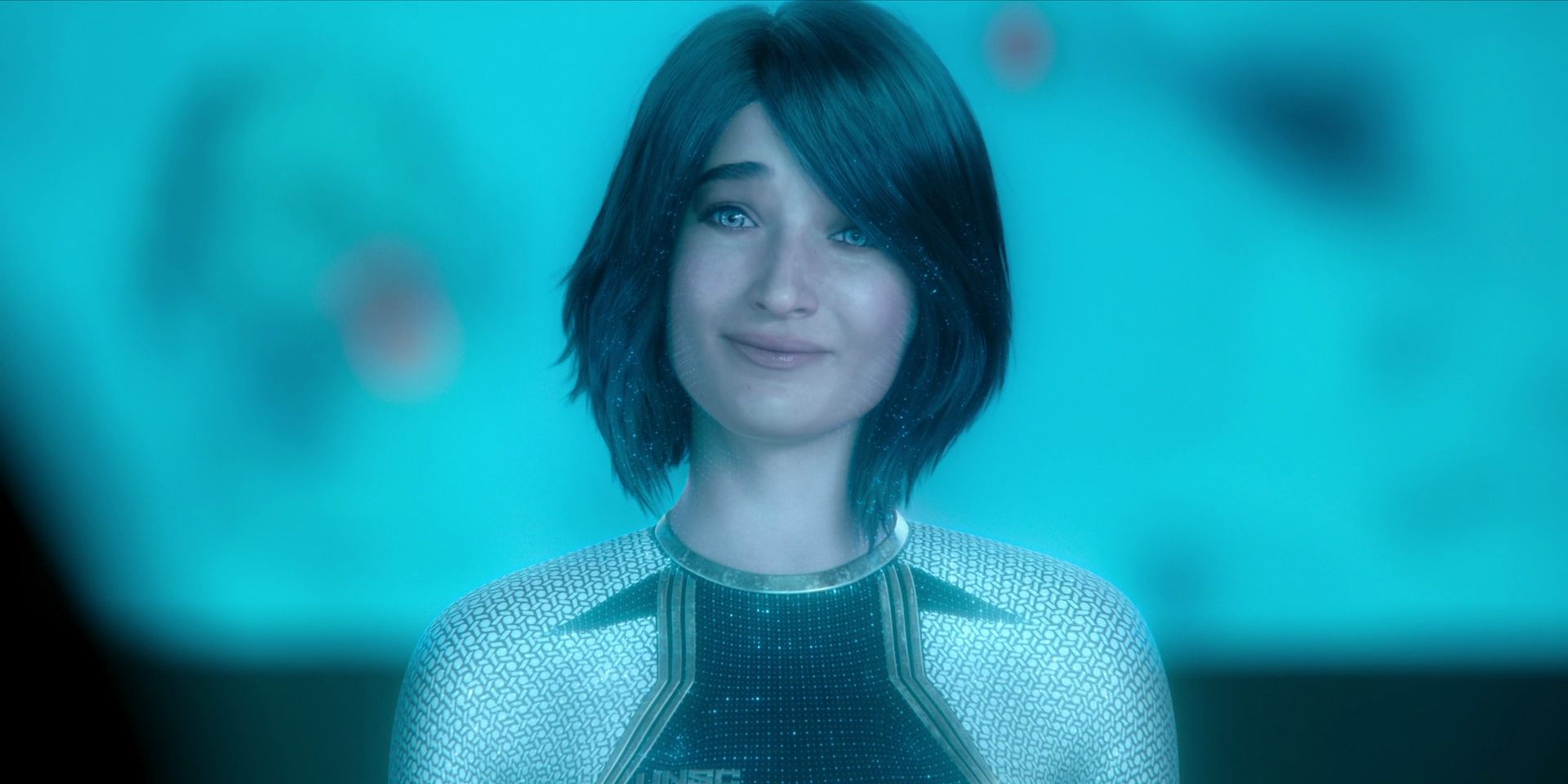 Cortana is a clearly-digital character wearing a UNSC-branded jumpsuit. She is a young white woman with blue eyes and shoulder-length dark hair with blue digital specks in it.