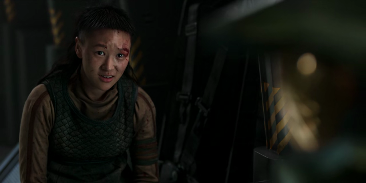 Kwan Ha, still with blood on her face, sits opposite the Master Chief, looking upset and furious.