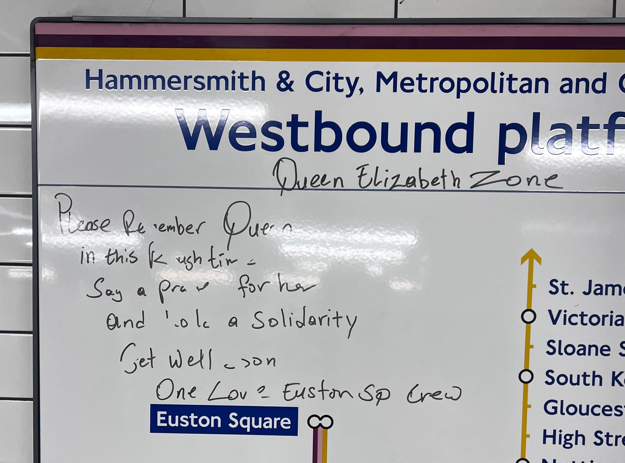 In marker pen: "Queen Elizabeth Zone. Please remember Queen in this Rush time - Say a pray for her and lotta solidarity. Get well soon. One love Euston Sq crew." On an enamel tube line diagram for westbound trains at Euston Square.