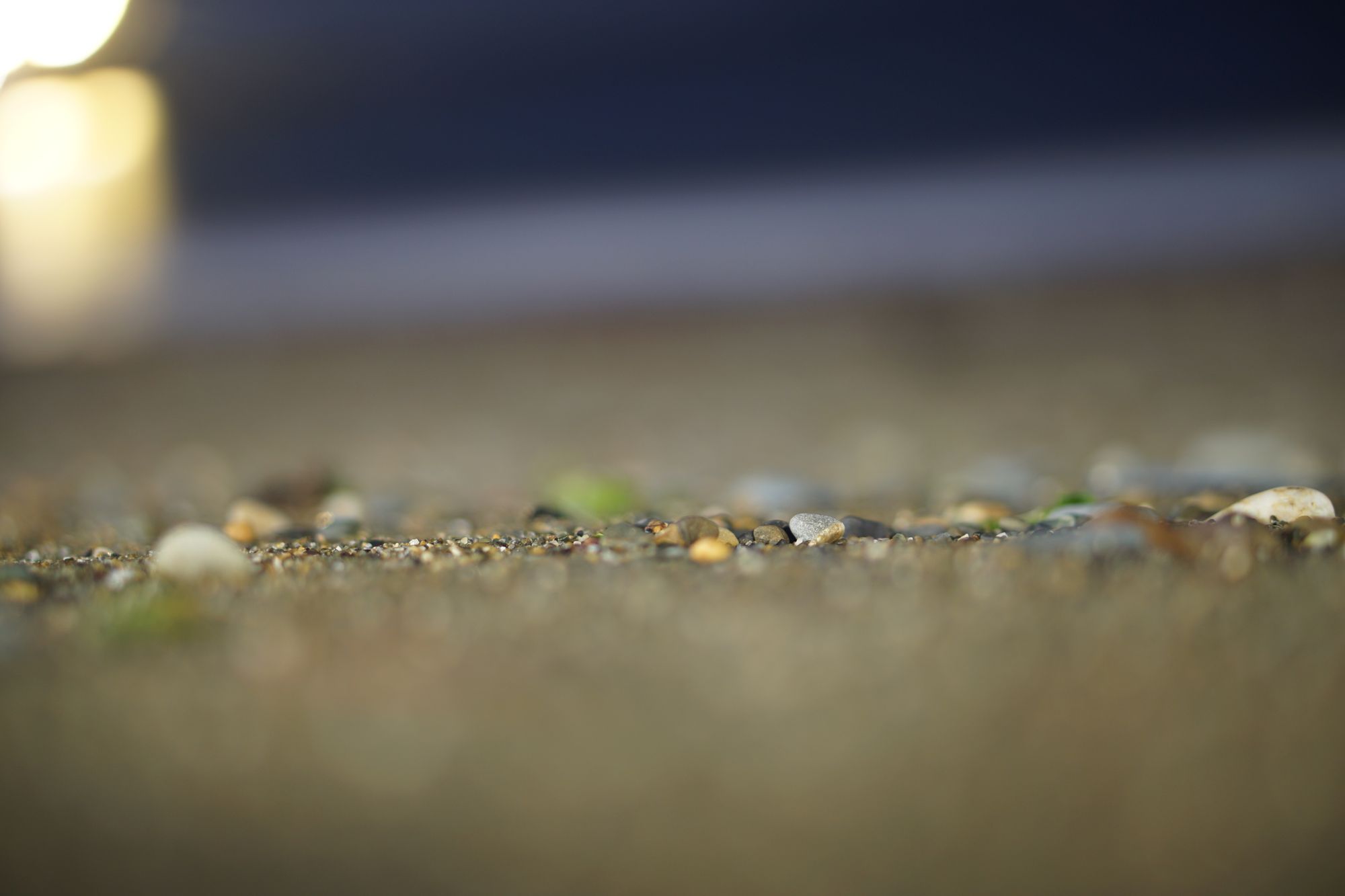 Close focus on shingle on the beach at night.