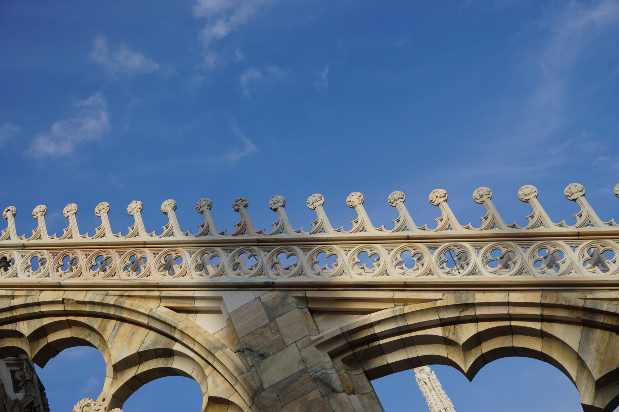 A gothic marble flying buttress with arches beneath and detailing on the top.