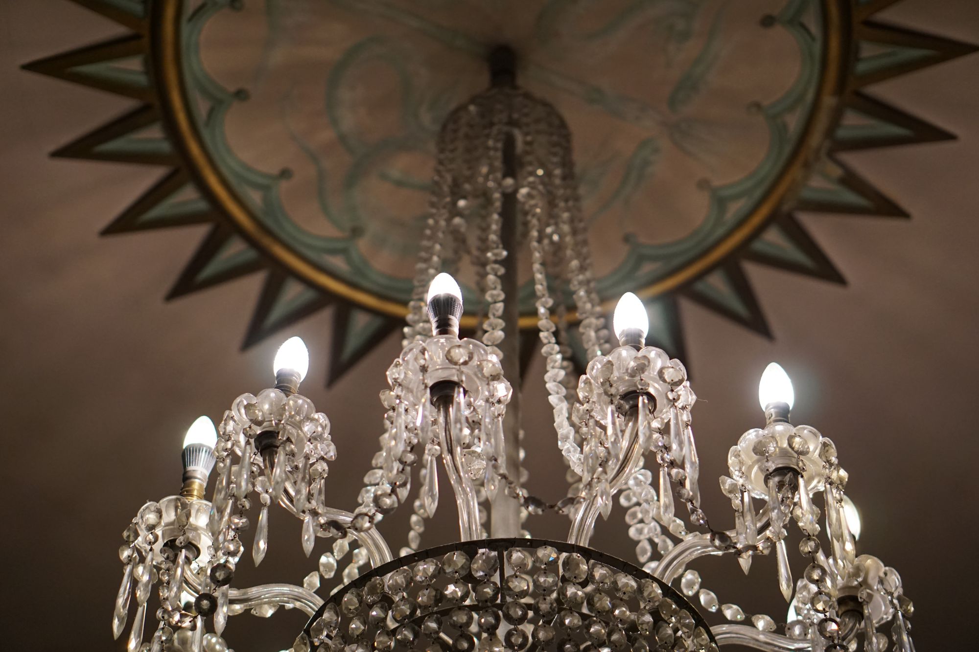 Another, slightly smaller and more tasteful, chandelier, with glass ‘pearl’ and ‘teardrop’ like formations forming a circle.